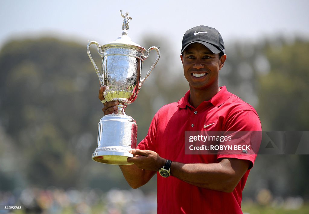 Tiger Woods of the US holds his trophy a