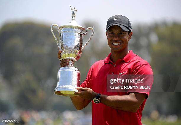 Tiger Woods of the US holds his trophy after defeating compatriot Rocco Mediate in the sudden death playoff at the 108th U.S. Open golf tournament at...