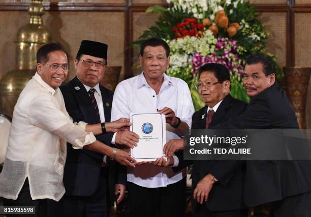 Philippine President Rodrigo Duterte poses with Secretary of the Peace Process Jesus Dureza , Al-Hajj Murad , chairman of Moro Islamic Liberation...