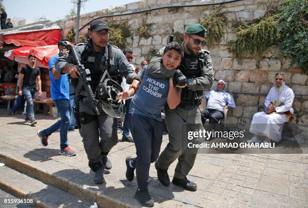 Israeli border guards detain a Palestinian youth during a demonstration outside the Lions Gate, a main entrance to Al-Aqsa mosque compound, due to...