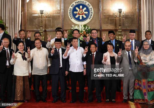 Philippine President Rodrigo Duterte , along with members of government and Moro Islamic Liberation Front peace representatives, gestures with the...
