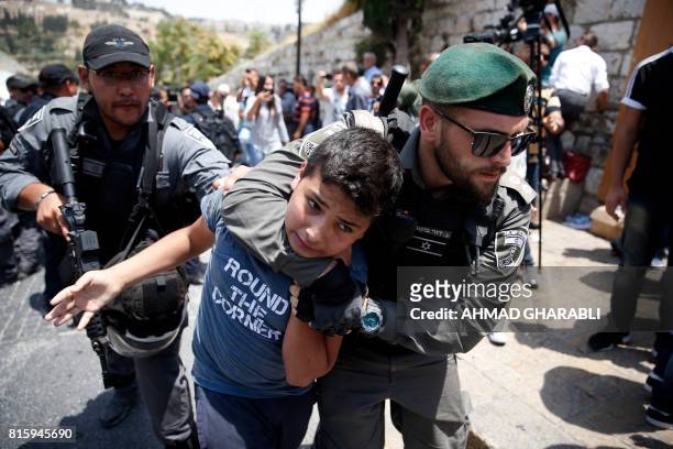 Israeli border guards detain a Palestinian youth during a demonstration outside the Lions Gate, a main entrance to Al-Aqsa mosque compound, due to...