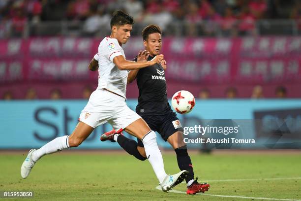 Joaquin Correa of Sevilla FC and Riku Matsuda of Cerezo Osaka compete for the ball during the preseason friendly match between Cerezo Osaka and...