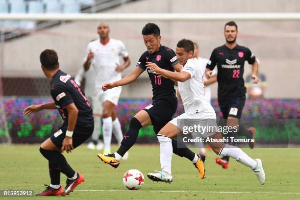 Wissam Ben Yedder of Sevilla FC and Hotaru Yamaguchi of Cerezo Osaka compete for the ball during the preseason friendly match between Cerezo Osaka...