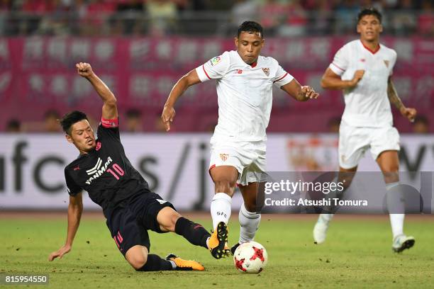 Luis Muriel of Sevilla FC is tackled by Hotaru Yamaguchi of Cerezo Osaka during the preseason friendly match between Cerezo Osaka and Sevilla FC at...