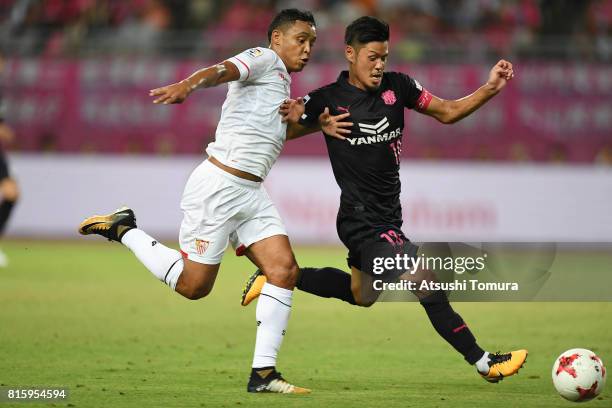 Luis Muriel of Sevilla FC and Hotaru Yamaguchi of Cerezo Osaka compete for the ball during the preseason friendly match between Cerezo Osaka and...