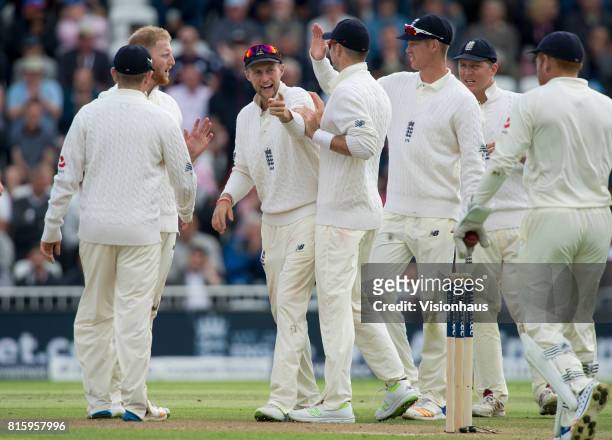Joe Root of England celebrates with his team mates after the wicket of Faf du Plessis of South Africa during the first day of the second test between...
