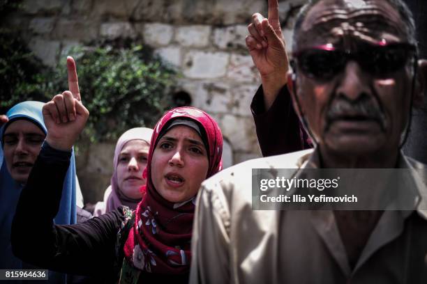 Palestinian Muslims protest praying outside the entrance to the old city of Jerusalem as it is partially blocked by Israeli Police on July 17, 2017...