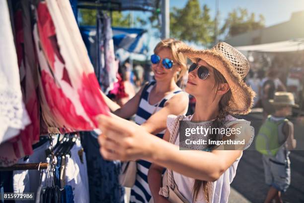 mother and daughter buying clothes  on flea market in andalusia, spain - local girls stock pictures, royalty-free photos & images