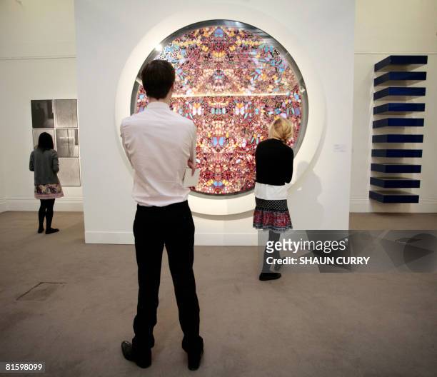 Visitors look at a painting entitled 'Rapture' by British artist Damien Hirst during a press view of Impressionist and Modern Art at Sotheby's...