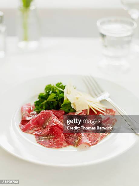 beef carpaccio with parmigiano reggiano and italian parsley. - carpaccio alimento fotografías e imágenes de stock