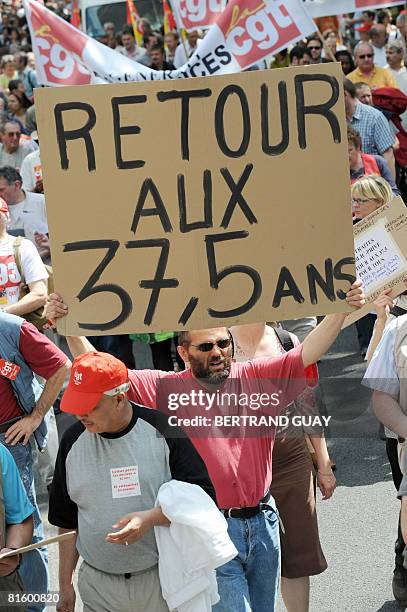 Man holds a board reading "Back to the 37,5 years" as he demonstrates as part of a nationwide strike called by the two biggest unions CGT and CFDT on...