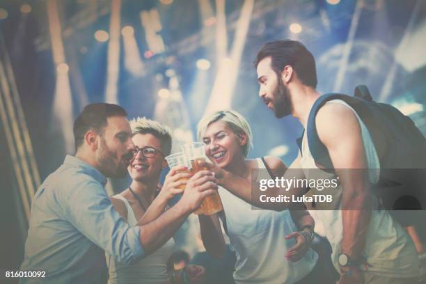 aantrekkelijk en hipster mensen maken van toast met bier op concert - drinking beer festival stockfoto's en -beelden