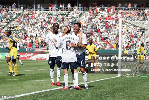 Brian Ching of the USA celebrates his late second half goal with teammates Steve Cherundolo and Eddie Johnson of the USA as goalkeeper Alvin Rouse...