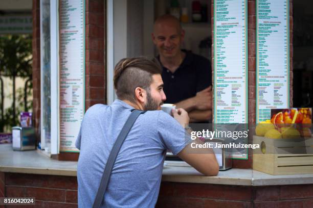 ragusa, sicilië: jonge man met hip kapsel, koffie buitenbar - italiaanse etniciteit stockfoto's en -beelden