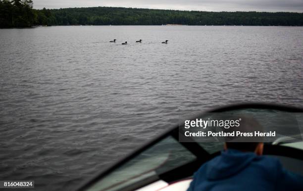 Alex Kimble looks out on loons a few yards away from him and his dad, Nathan Kimble, on Crescent Lake. The Kimbles volunteered for Maine Audubon to...