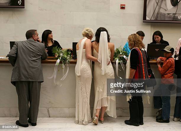 Same-sex couple Amber Weiss and Sharon Papo stand in line to receive their marriage license before getting married at San Francisco City Hall June...