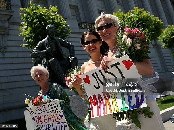 Same-sex couple Amber Weiss and Sharon Papo walk with Patty Weiss by an Abraham Lincoln statue after they were married at San Francisco City Hall...