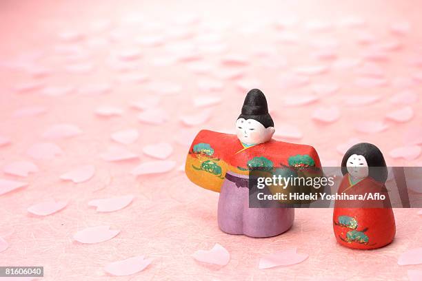 japanese traditional figurines with sakura petals - girls day stockfoto's en -beelden