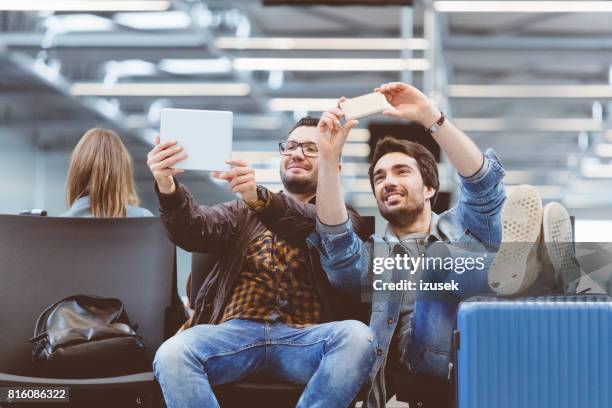 schöne männer nehmen selfie mit smartphone und digitale pc - cell mates stock-fotos und bilder