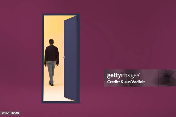 man walking threw doorway in futuristic room - selandia fotografías e imágenes de stock