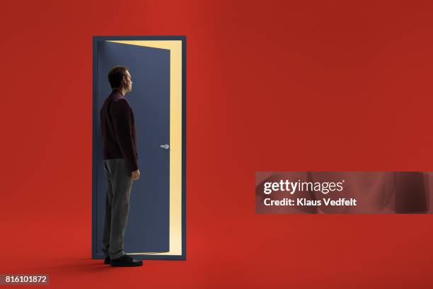 man standing in front of half open door - opposite directions stock pictures, royalty-free photos & images