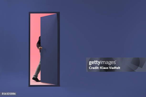 man walking threw doorway in futuristic room - mystery door stock pictures, royalty-free photos & images