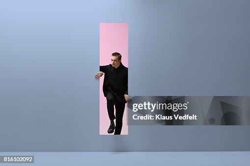 Man walking threw rectangular opening in coloured room Man walking threw rectangular opening in coloured room