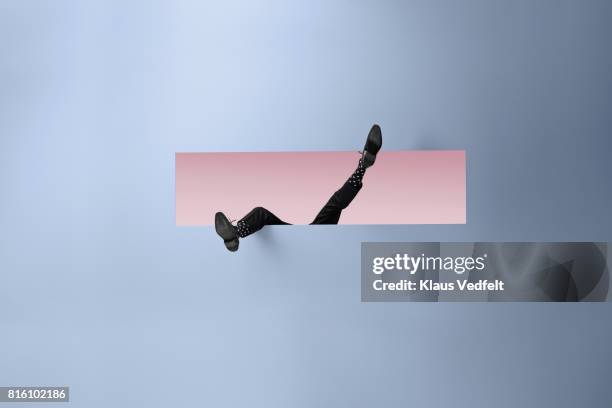 feet of businessman, sticking out rectangular opening in coloured wall - pink shoe fotografías e imágenes de stock