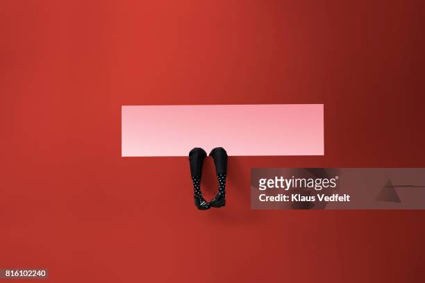 feet of businessman, sticking out rectangular opening in coloured wall - men socks foto e immagini stock