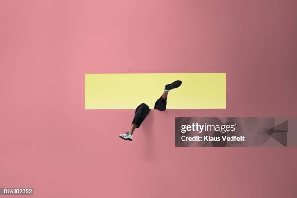 womans legs sticking out of rectangular opening in coloured wall and looking up - pink shoe bildbanksfoton och bilder