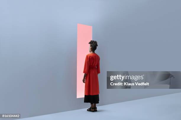 woman standing in front of rectangular opening in coloured wall - alternative people stock pictures, royalty-free photos & images