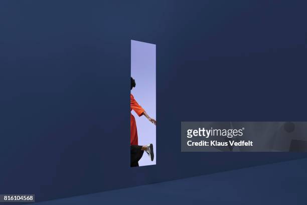 woman & man holding hands, approaching rectangular opening in coloured wall - öresundregion stock-fotos und bilder