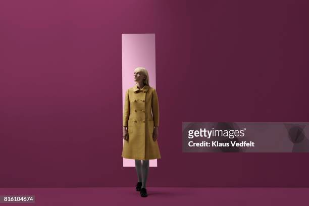 woman coming out of rectangular opening in coloured wall - getting out stock pictures, royalty-free photos & images