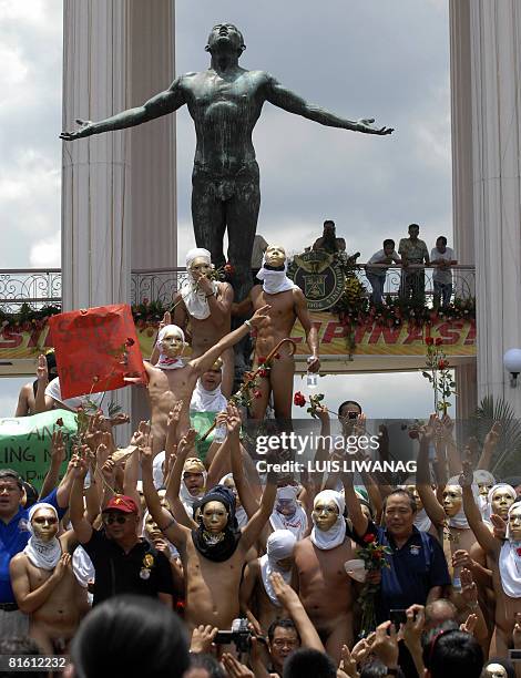 Some 100 nude members of the Alpha Phi Omega fraternity pose before the "Oblation" sculpture after a traditional 'oblation run' at the University of...