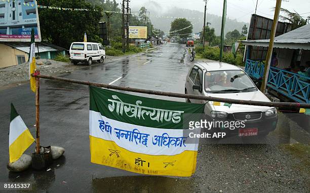 Banners of The Gorkha People's Liberation Front adorn a barrier partially blocking National Highway 55 on the outskirts of Siliguri on June 18 during...