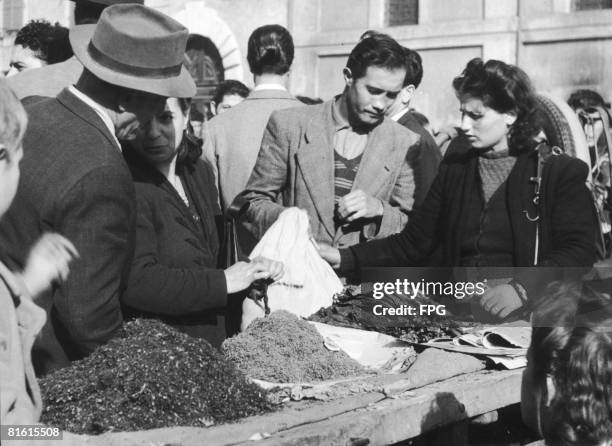 Tobacco is sold on the black market in Vittoria Square, Rome, circa 1945. Rationing allows men only four cigarettes per day, and women, none.