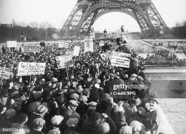 Striking Paris taxi drivers throw an effigy into the Seine, near the Eiffel Tower, circa 1920. The dummy symbolises the new regulation favouring...