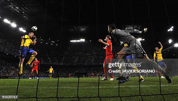Swedish defender Petter Hansson (L0 heads off the ball in front of teammate goalkeeper Andreas Isaksson during the Euro 2008 Championships Group D...