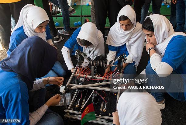Members of the Afghan all-girls robotics team make adjustments to the team robot in the practice area July 17 between 2017 FIRST Global Challenge...