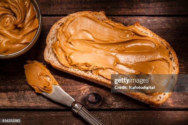 pindakaas op brood slice shot op rustieke houten tafel - pindakaas stockfoto's en -beelden