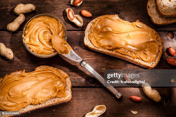 peanut butter toast am rustikalen holztisch erschossen - erdnussbutter stock-fotos und bilder