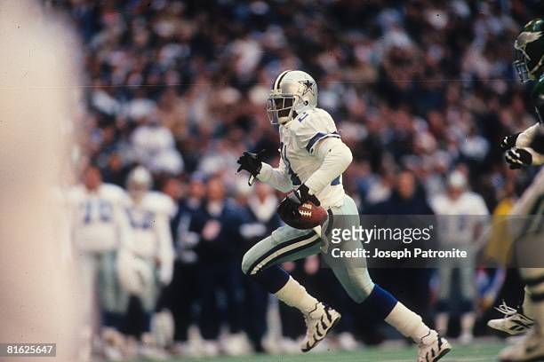 Defensive back Deion Sanders of the Dallas Cowboys returns a punt for a touchdown against the Philadelphia Eagles at Texas Stadium in the 1995 NFC...