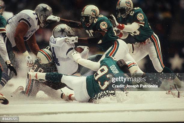 Running back Lincoln Coleman of the Dallas Cowboys is wrapped up by the Miami Dolphins defense at Texas Stadium on November 25, 1993 in Irving,...