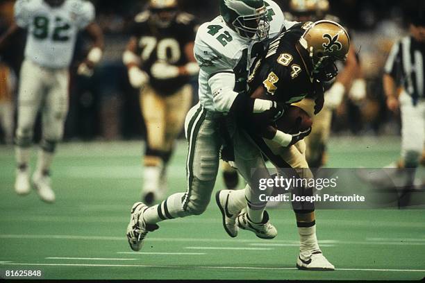 Wide receiver Eric Martin of the New Orleans Saints is brought down by cornerback John Booty of the Philadelphia Eagles at the Superdome in the 1992...