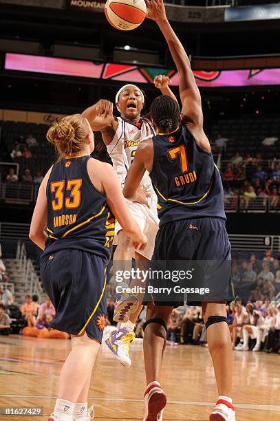 Cappie Pondexter of the Phoenix Mercury passes the ball over Jolene Anderson and Sandrine Gruda of the Connecticut Sun at U.S. Airways Center June...