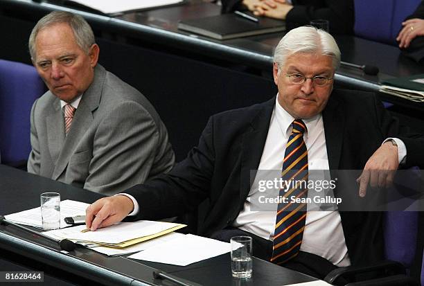 German Vice Chancellor and Foreign Minister Frank-Walter Steinmeier and Interior Minister Wolfgang Schaeuble listen to Chancellor Angela Merkel give...