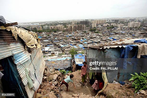 Indian children outrside their home in a slum of Mumbai on June 19, 2008. Millions have flocked to urban centres for work, contributing to the...