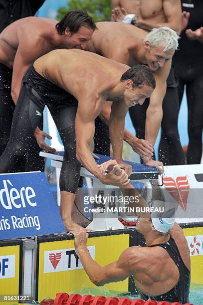 French swimmers Fabien Gilot, Frederick Bousquet and Amaury Leveaux congratulate their teammate Alain Bernard as he finished the final of the men...
