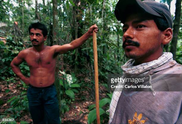 Two men work February19, 2001 on the the constuction of a camp near El Venado, Colombia, that will serve as a home to some 70 people convicted of...